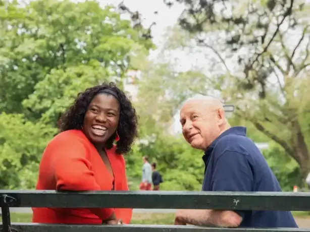 Caregiver and senior man sitting at Central Park